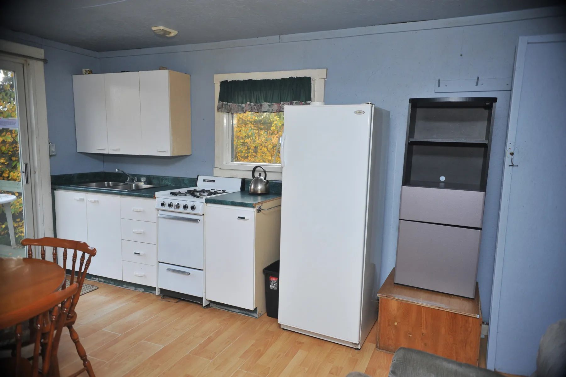 La cuisine fonctionnelle du chalet comprend une cuisinière, un réfrigérateur et un espace repas.