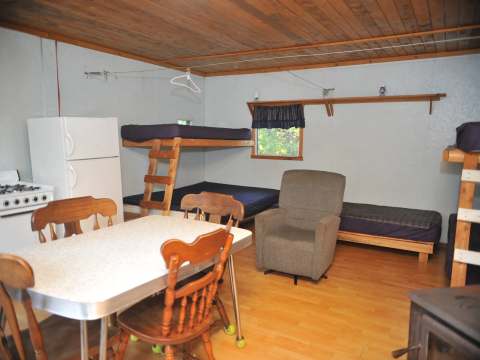 Interior view of Le Pionnier accommodation with its equipped kitchen and bunk beds.