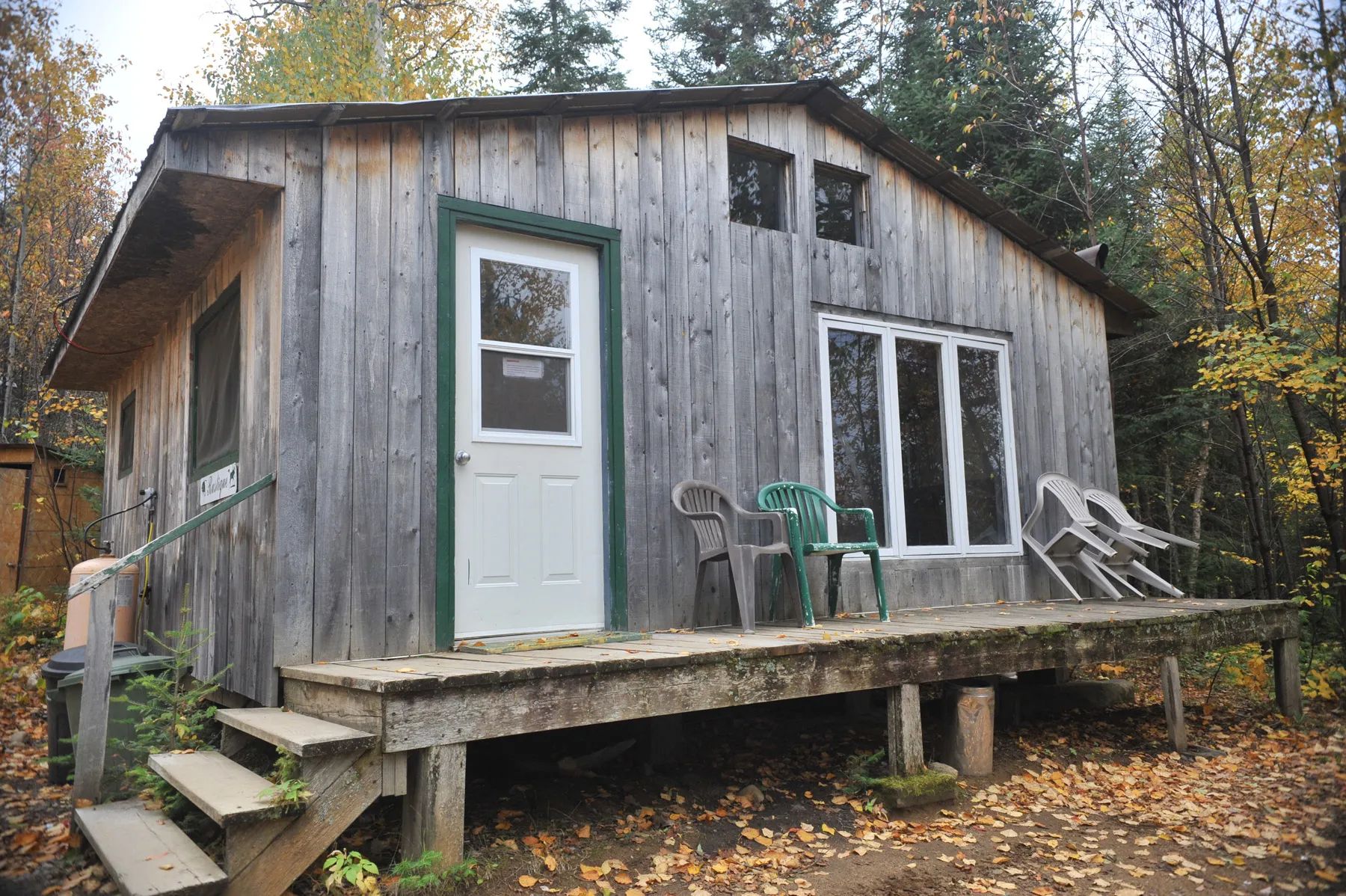 Le chalet Rustique dispose d'une galerie en bois et d'une façade en planches de bois vieilli.