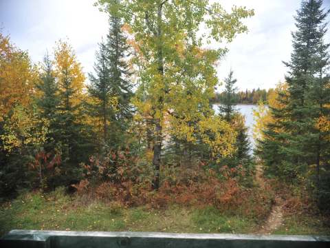 View of the autumn forest and lake from the cabin deck.