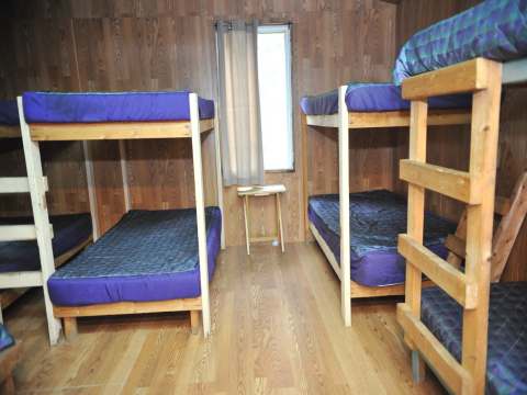 This room in Le Vétéran cottage features several wooden bunk beds.