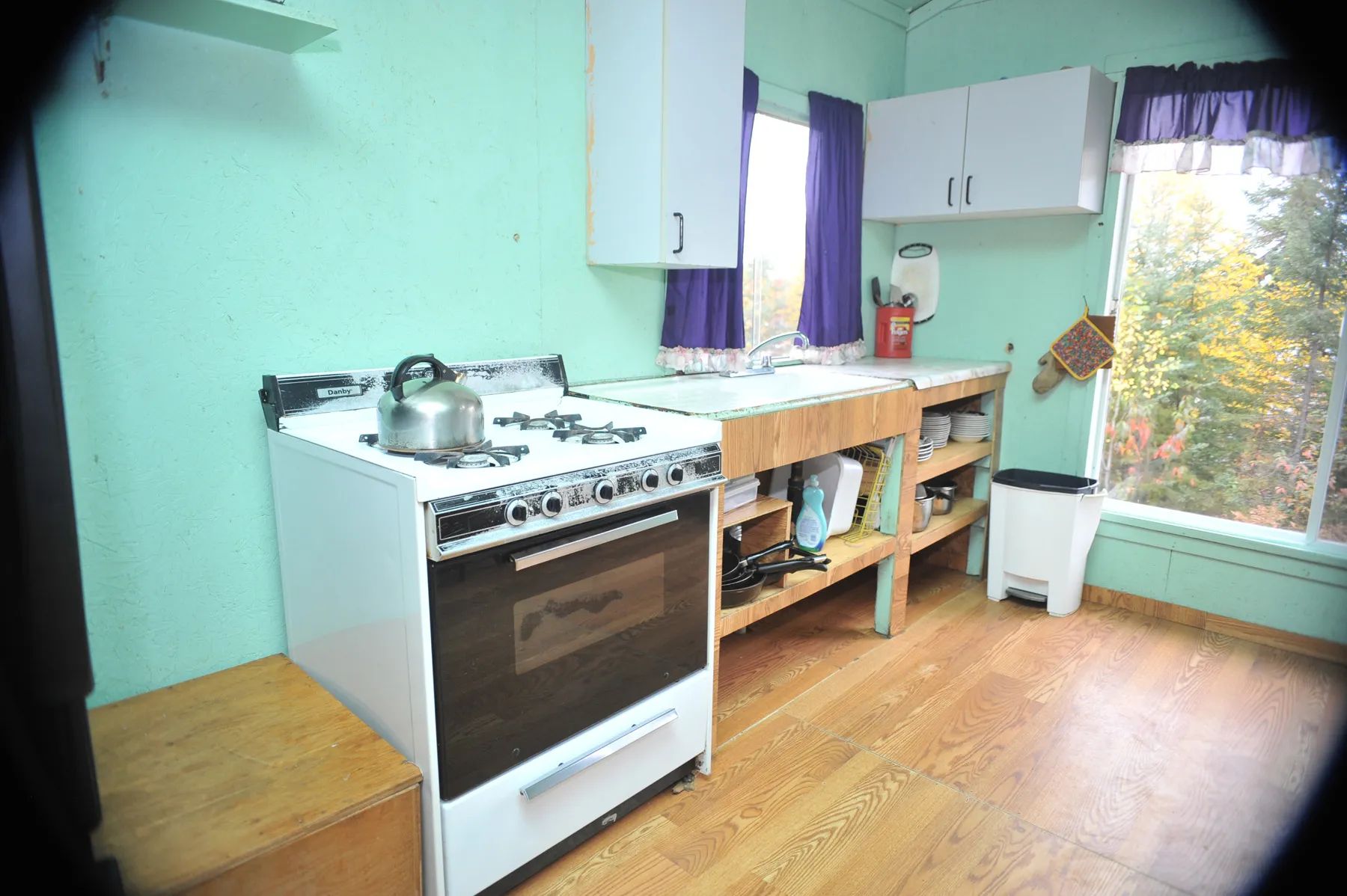 The cottage's functional kitchen is equipped with a stove and a counter with a sink.