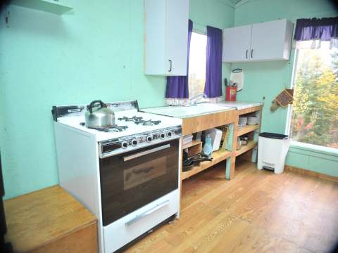 The cottage's functional kitchen is equipped with a stove and a counter with a sink.