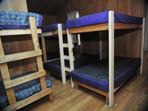 This bedroom at Le Vétéran cabin is equipped with several bunk beds.