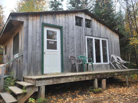 Le chalet Rustique dispose d'une galerie en bois et d'une façade en planches de bois vieilli.