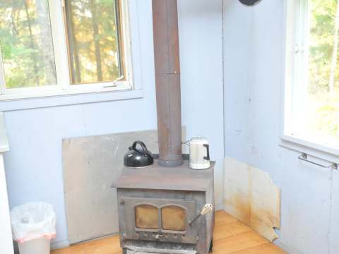 Un poêle à bois installe au coin de la pièce principale du chalet.