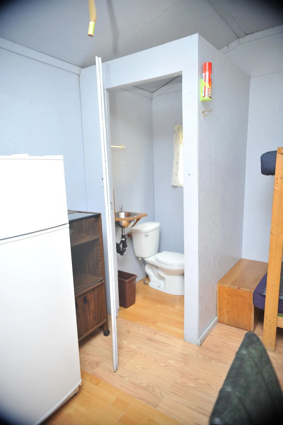 Vue intérieure du chalet incluant un coin salle de bain avec toilette et lavabo.