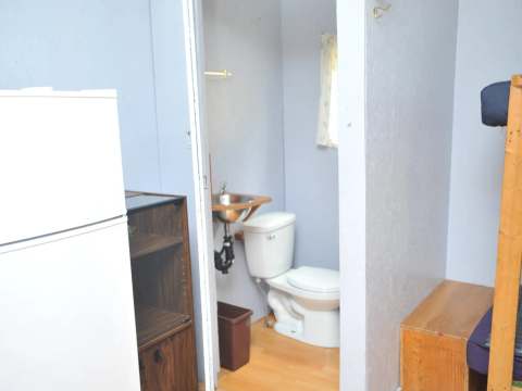Vue intérieure du chalet incluant un coin salle de bain avec toilette et lavabo.
