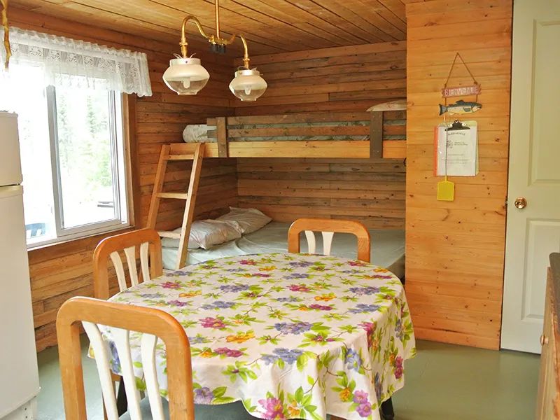 Coin repas et lit superposé au sein du chalet Le Colibri.