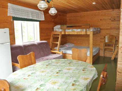 L'intérieur du chalet Geai bleu comprend une table à manger, un divan et des lits superposés en bois.