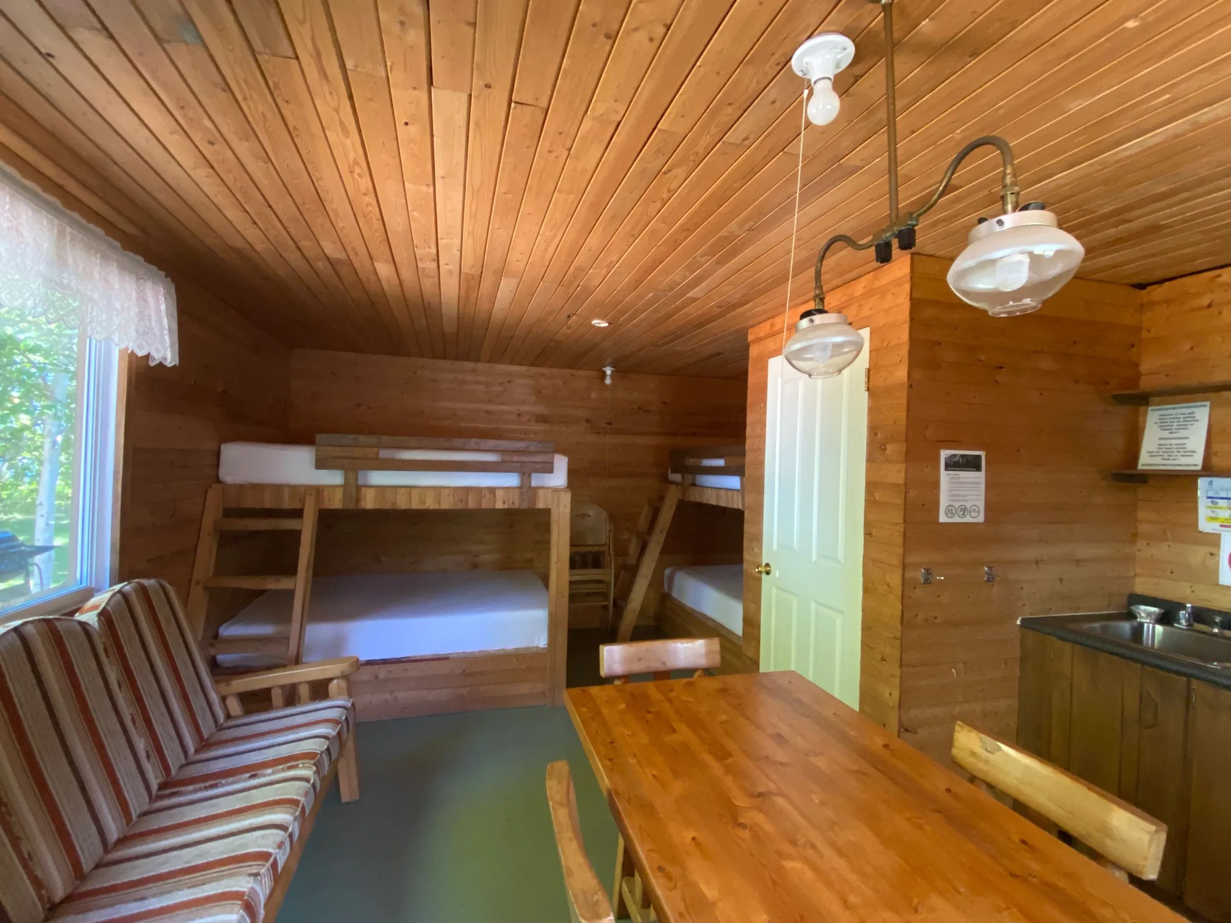 L'intérieur du chalet Le Geai bleu dispose de lits superposés, d'une table à manger et d'un coin cuisine.