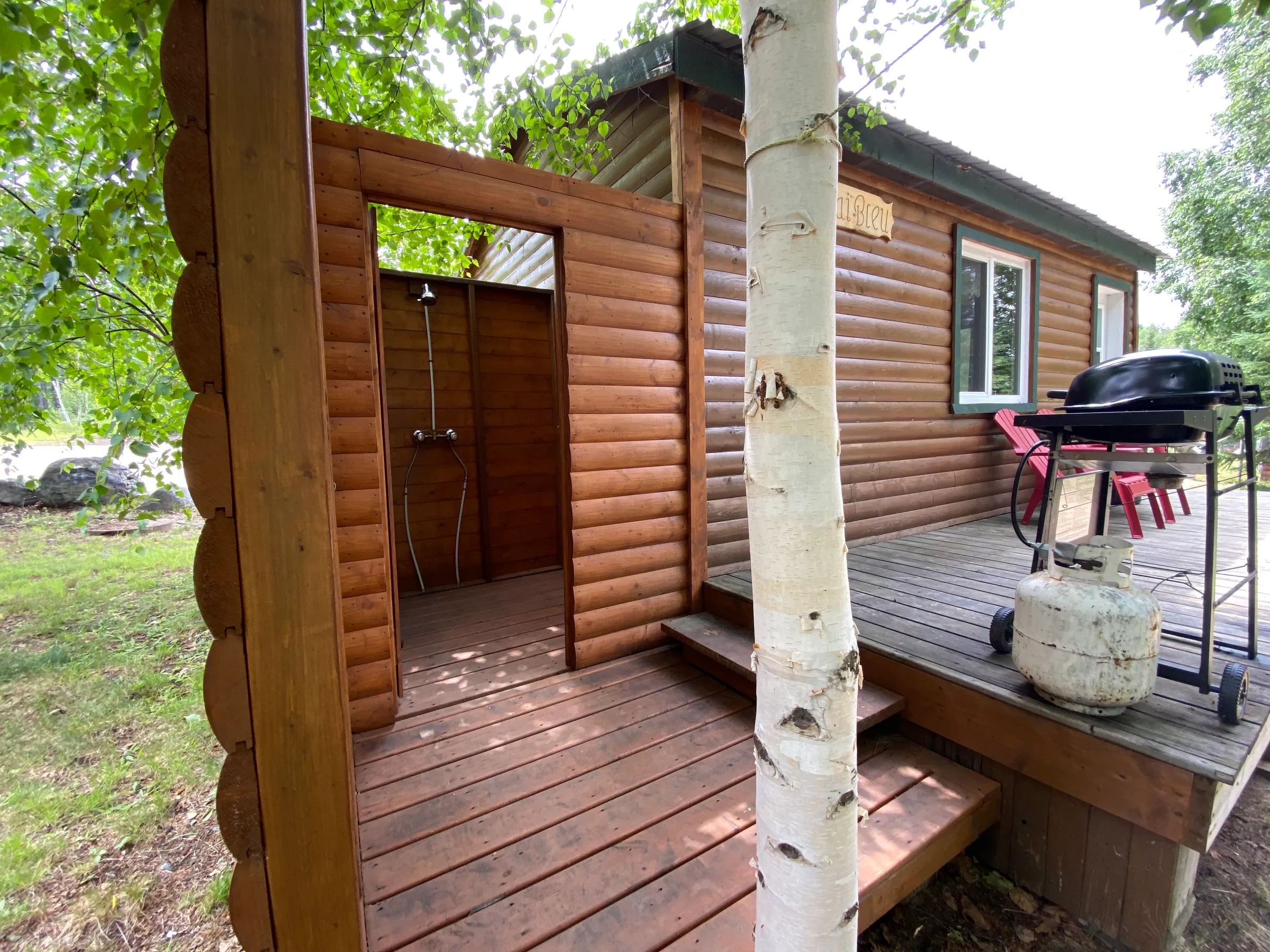 La galerie du chalet Le Geai bleu est équipée d'une douche extérieure et d'un barbecue au propane.