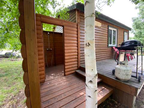 La galerie du chalet Le Geai bleu est équipée d'une douche extérieure et d'un barbecue au propane.