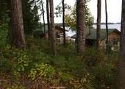 View of the rustic cabins nestled along the forest edge and the lake.