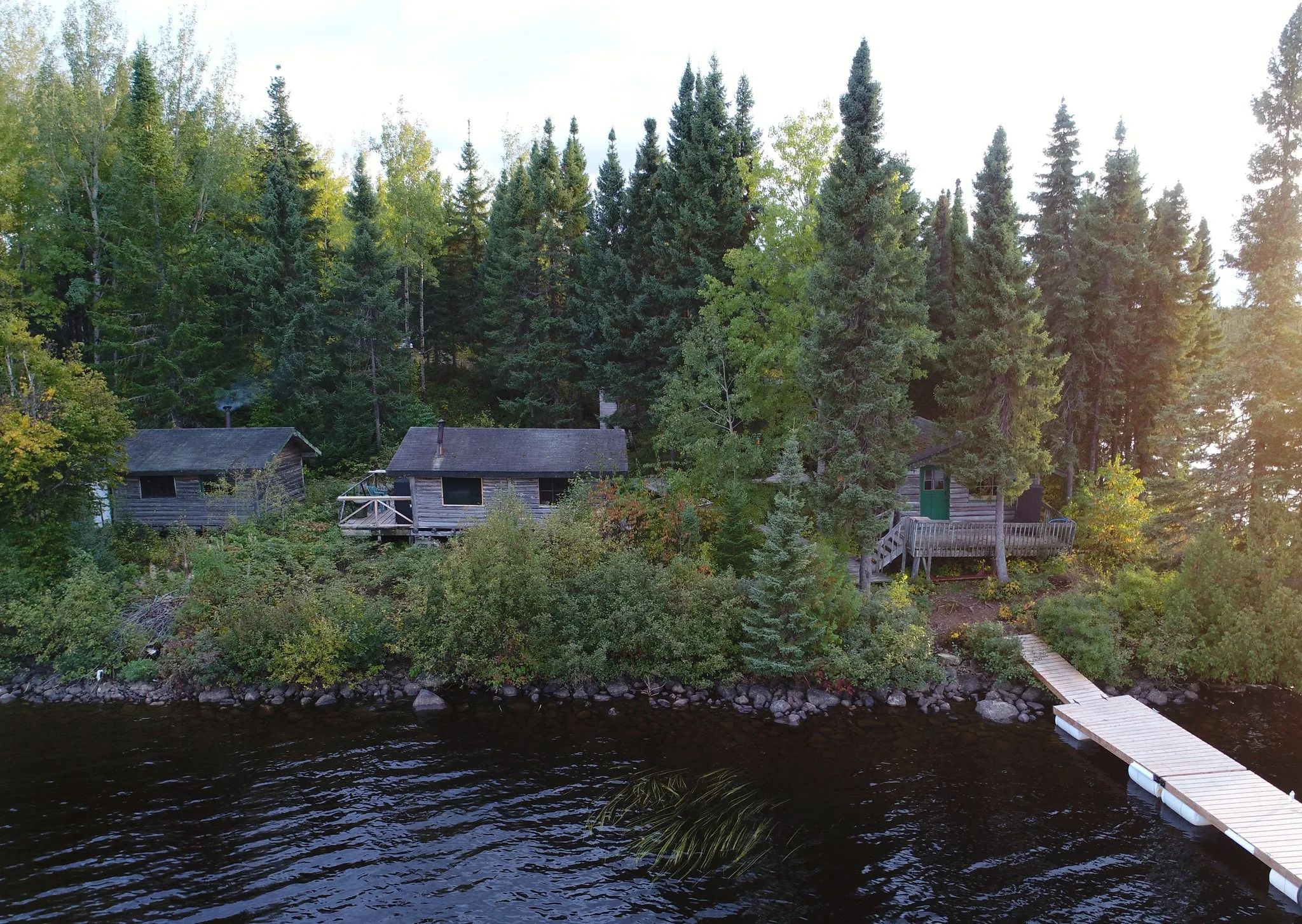 Aerial view of rustic cabins located by the lake with their private docks.