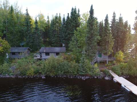 Aerial view of rustic cabins located by the lake with their private docks.