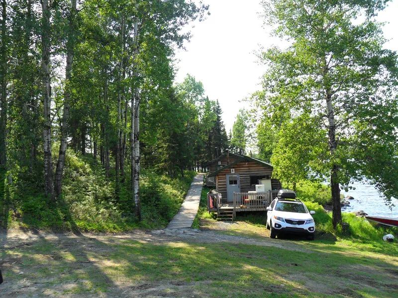Exterior view of the rustic cabin located in close proximity to the lake.