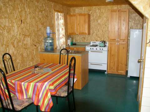 The equipped kitchen includes a dining table, a stove, and a refrigerator.
