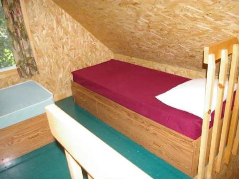 View of the attic bedroom with two single beds in the cabin.