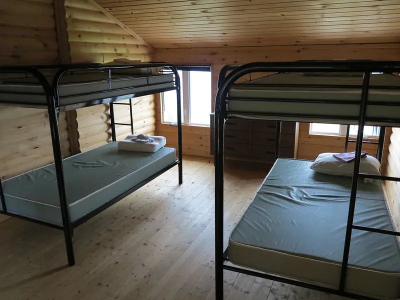 Une chambre avec deux lits superposés dans le chalet en bois rond.