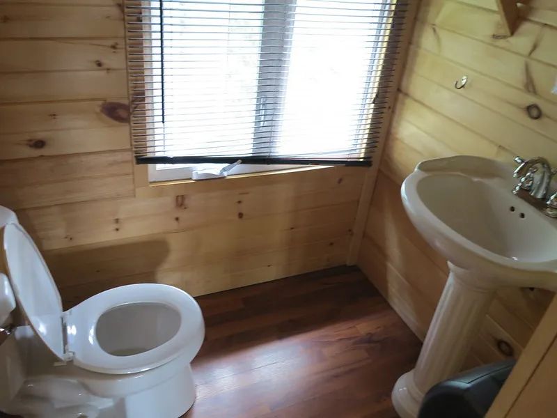 La salle de bain du chalet Le Grand Duc comprend une toilette et un lavabo sur pied.