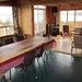 La salle à manger lumineuse du chalet avec une grande table et une vue sur l'extérieur.