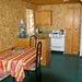 La cuisine fonctionnelle du chalet comprend une table à manger, une cuisinière et des rangements.