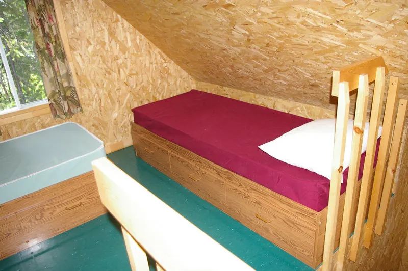 Vue de la chambre sous les combles avec deux lits simples dans le chalet.