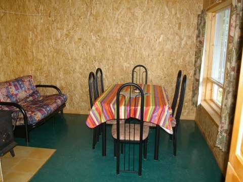 La salle à manger du chalet L'Épervier comprend une table familiale et un sofa.