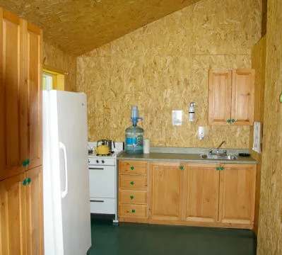 La cuisine équipée du chalet l'Épervier comprend un réfrigérateur, une cuisinière et un évier.