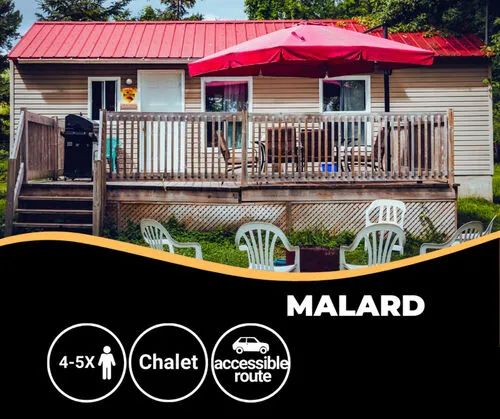 The Kakawi chalet features a large deck equipped with a barbecue and a patio umbrella.