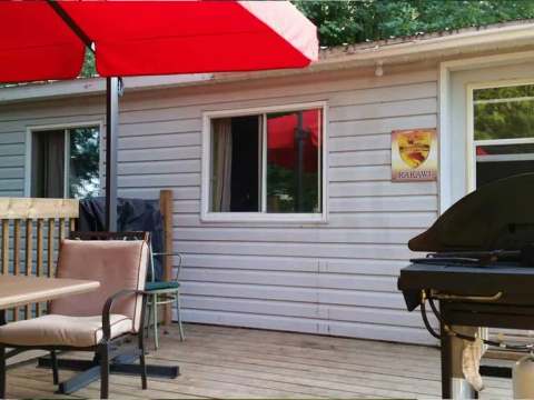 The outdoor terrace of the Kakawi cottage is equipped with a barbecue and a table with an umbrella.