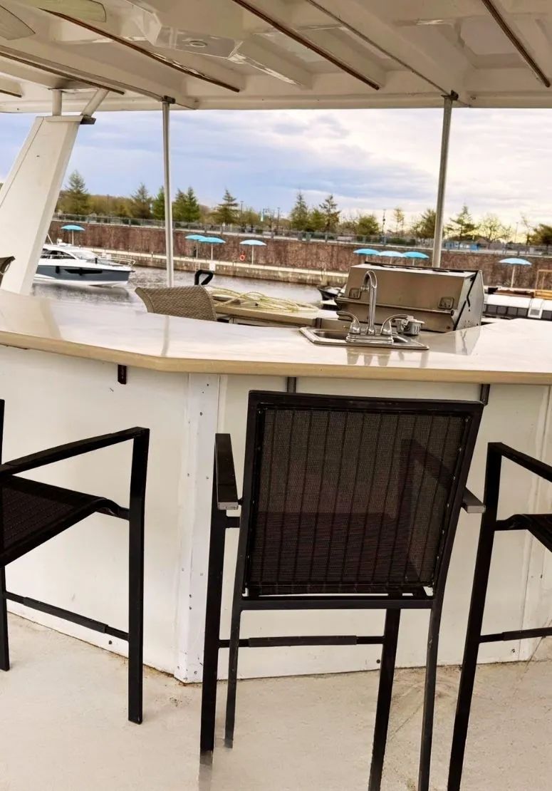 A counter with sink and high chairs located on the accommodation's covered terrace.