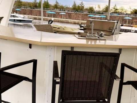 A counter with sink and high chairs located on the accommodation's covered terrace.