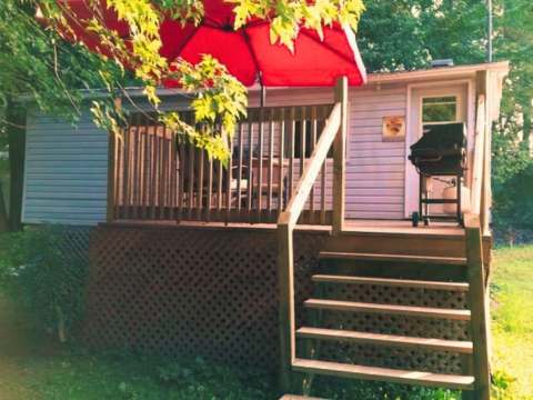 Le chalet Kakawi dispose d'une galerie extérieure avec un barbecue et un parasol.