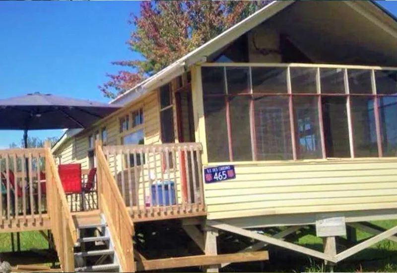 Le chalet Le Grand Duc offre une terrasse en bois équipée d'un parasol et de mobilier extérieur.