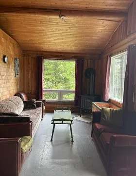 The cottage living room is furnished with comfortable sofas and a wood stove.
