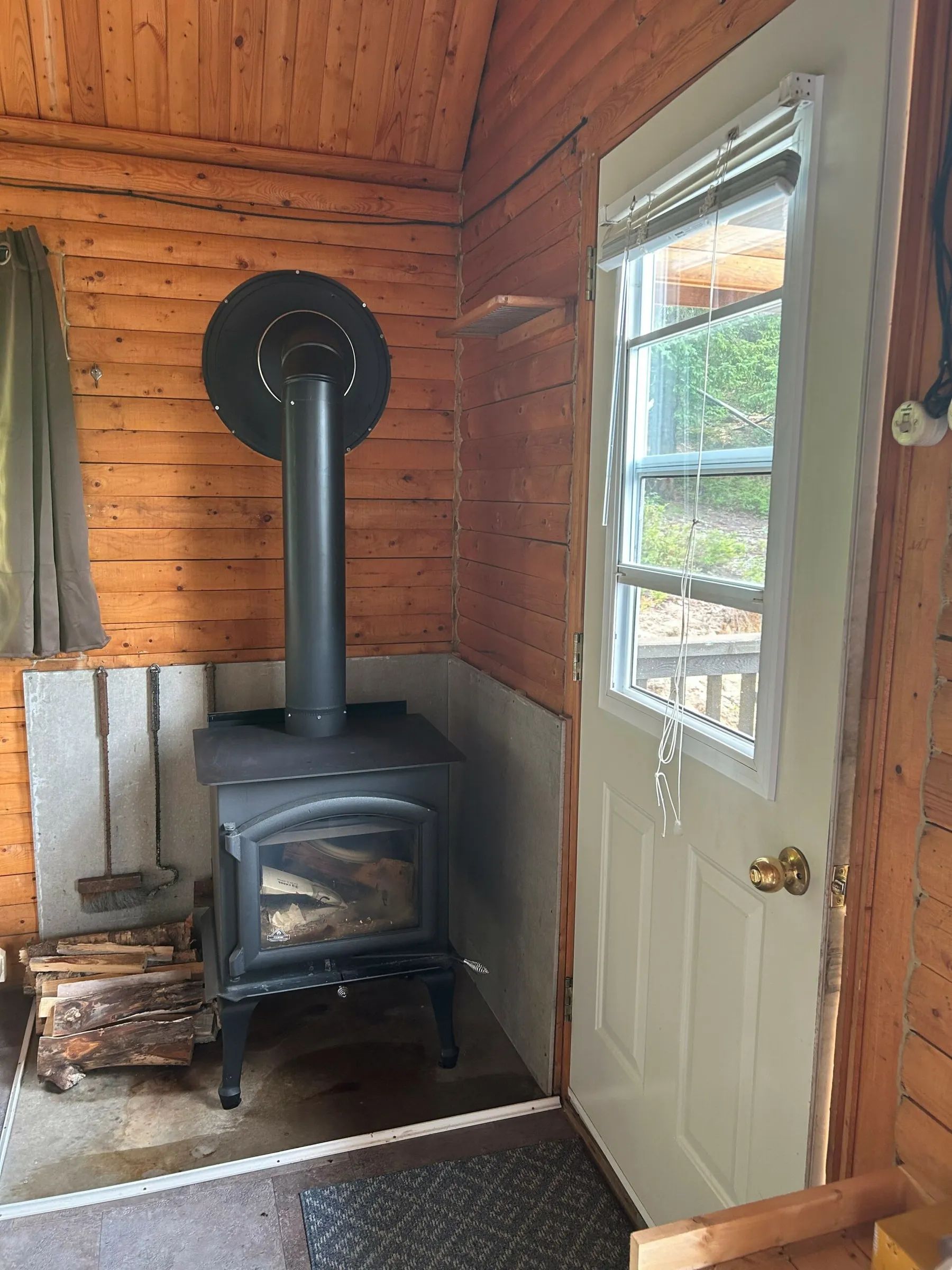 Le poêle à bois dans le coin du chalet Le Trappeur offre une ambiance chaleureuse.