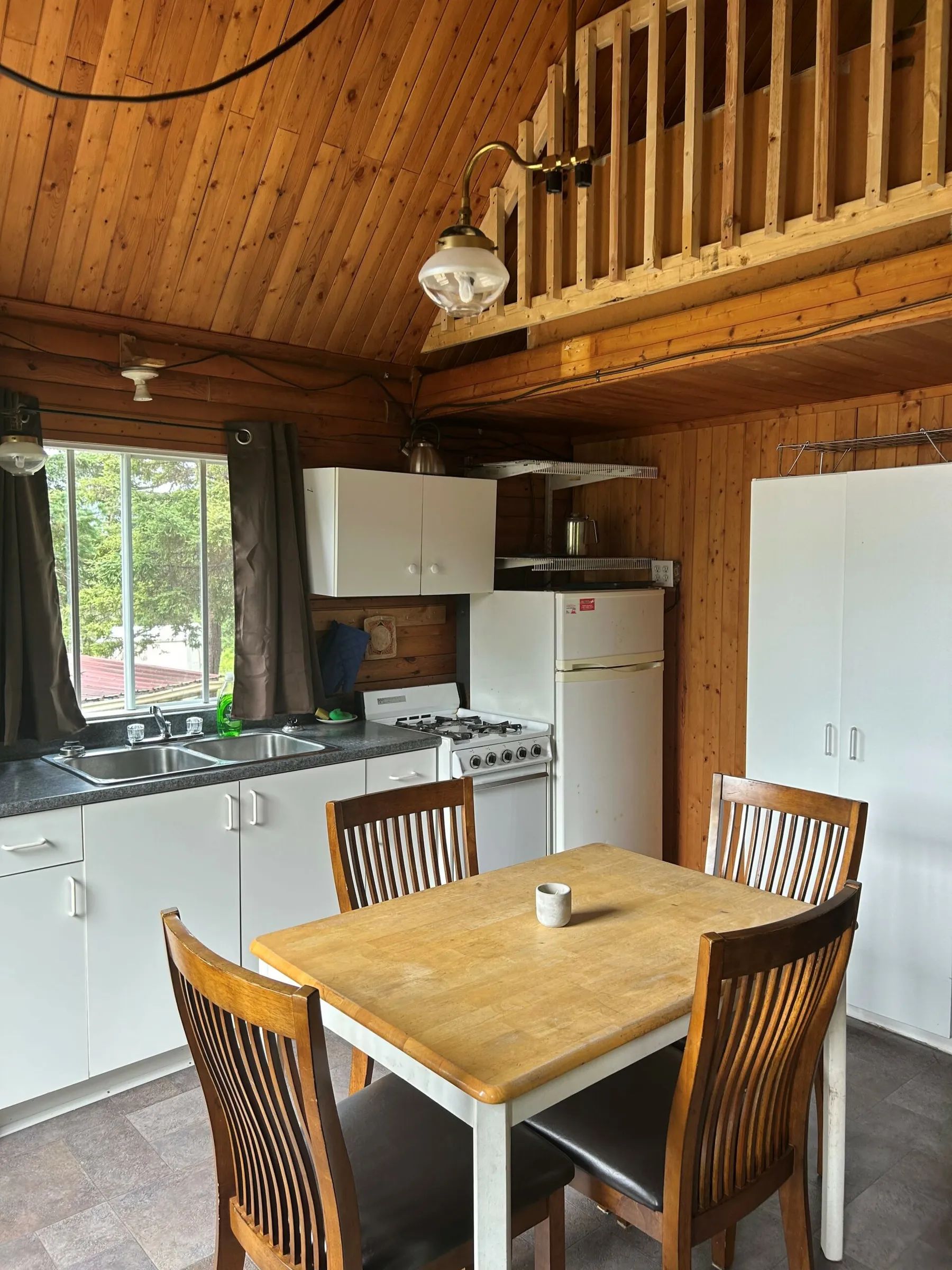 La cuisine fonctionnelle du chalet Le Trappeur comprend une table à manger et des équipements de base.