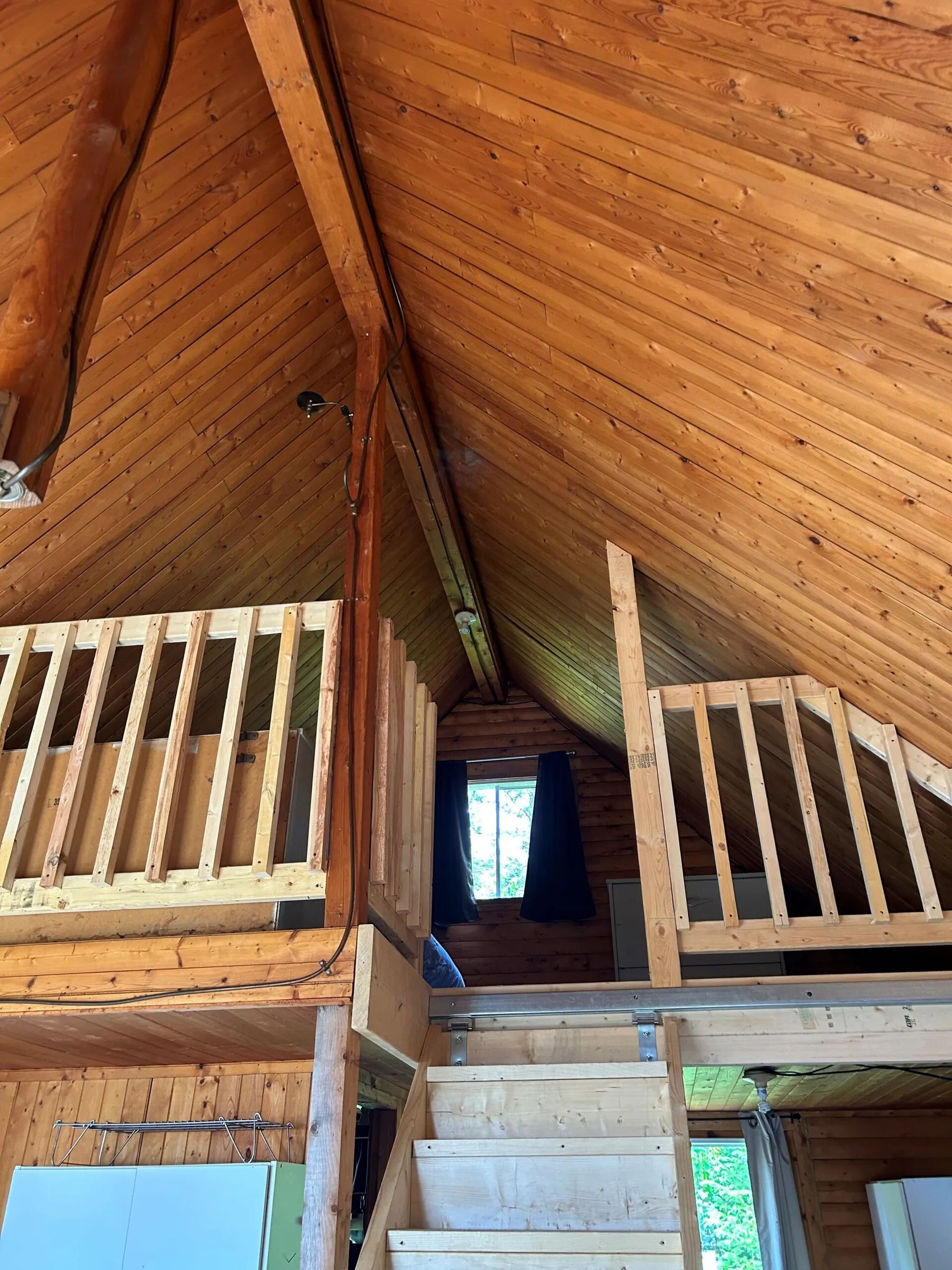 Vue sur la mezzanine en bois du chalet Le Trappeur.