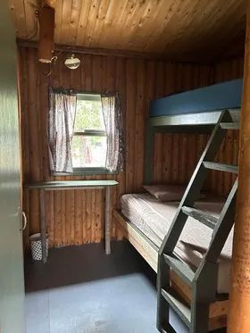 This rustic bedroom features a wooden bunk bed in the Vieux Camp cabin.