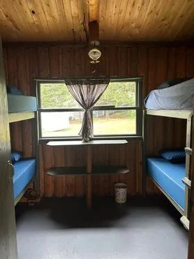 This rustic bedroom at Le Vieux Camp cabin is equipped with two wooden bunk beds.