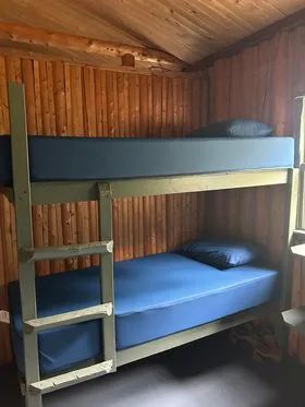 A bunk bed with blue mattresses in the cottage bedroom.