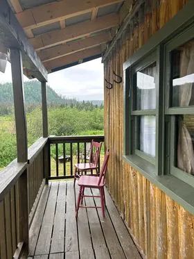 La galerie du chalet offre une vue sur la forêt environnante.