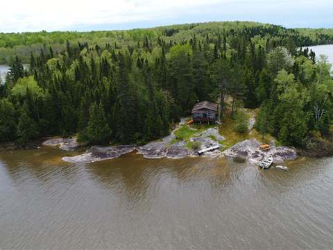 Vue aérienne de notre chalet privé situé sur une île boisée entourée par le lac.