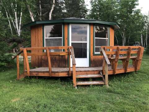 Façade extérieure du chalet en bois doté d'une terrasse avec bancs intégrés.