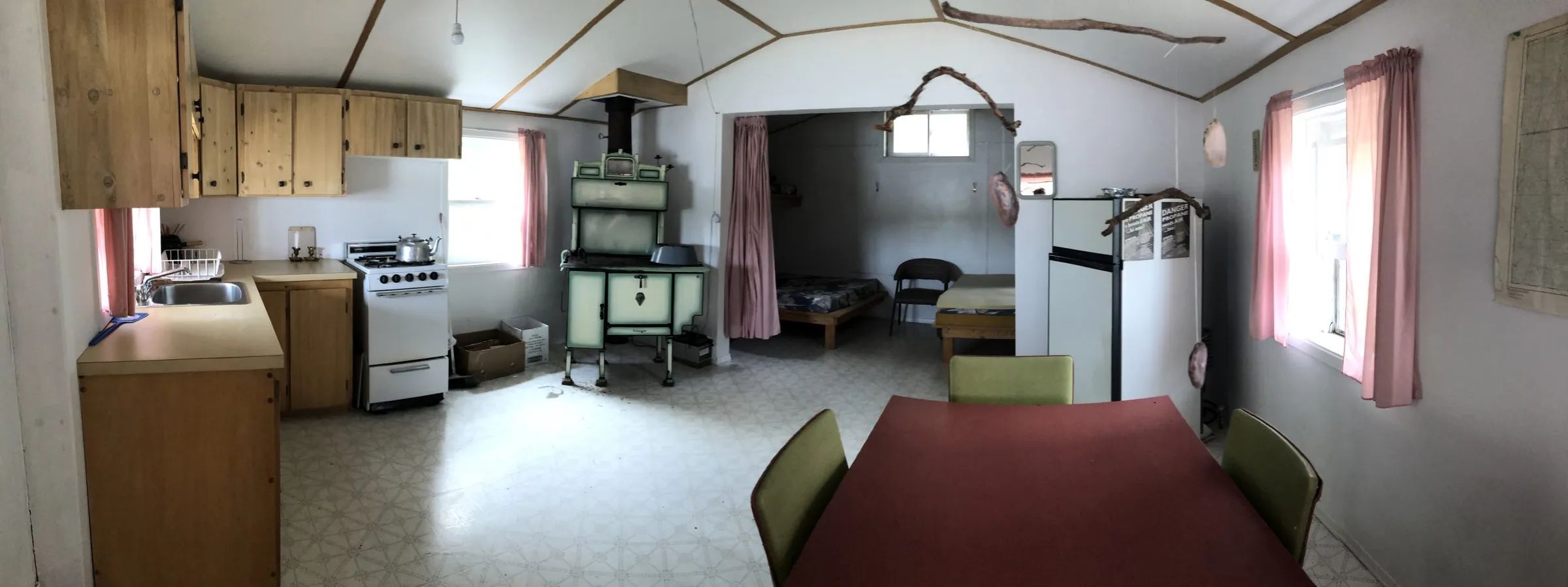 L'espace de vie du chalet comprend une cuisine équipée, un poêle à bois et un coin salle à manger.
