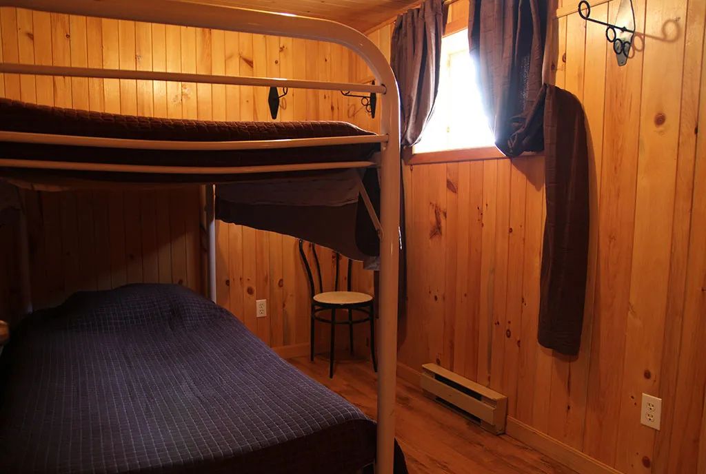 This cottage bedroom is equipped with a metal bunk bed.