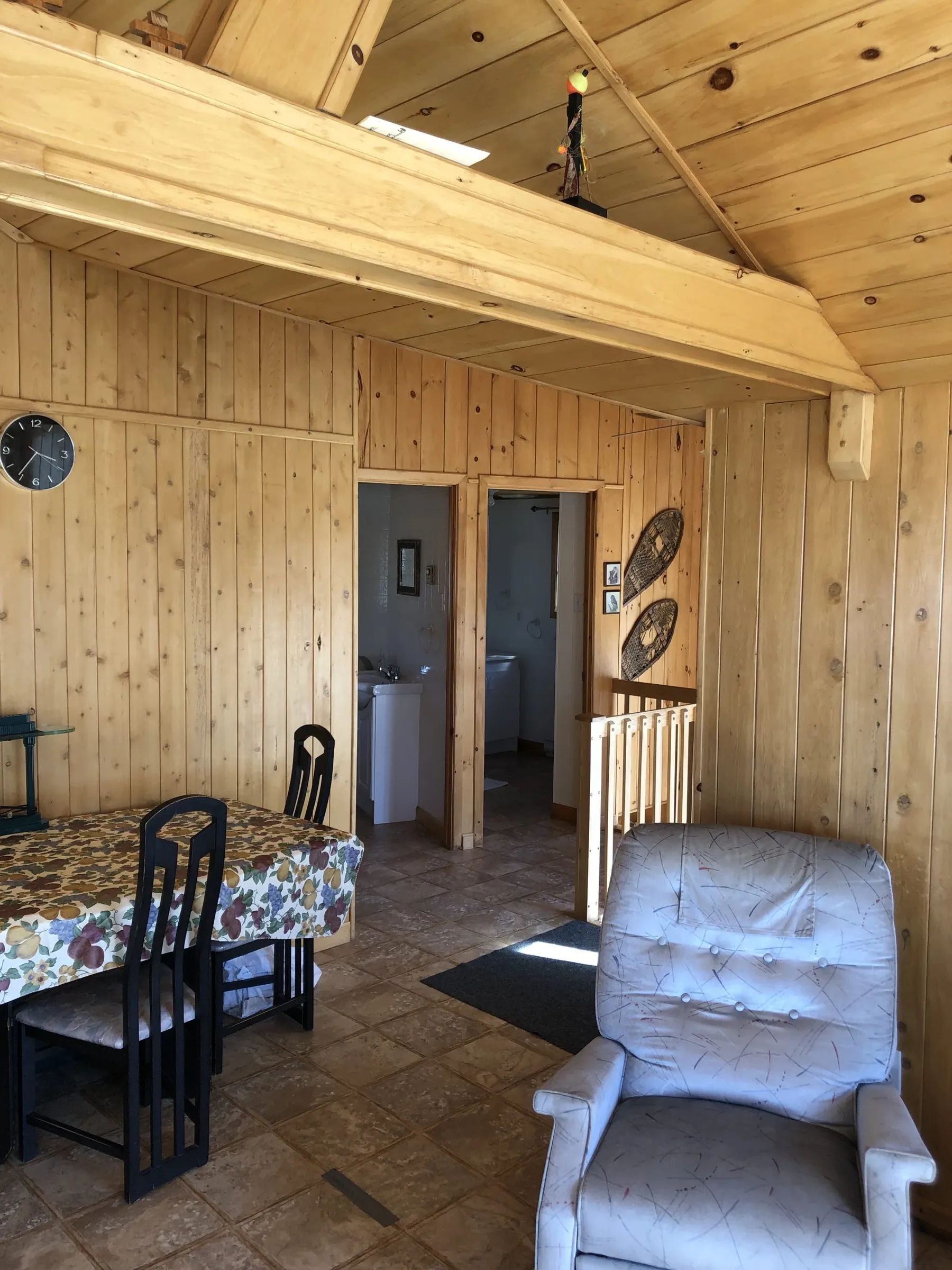 The cabin's living area with a dining table and a comfortable armchair.