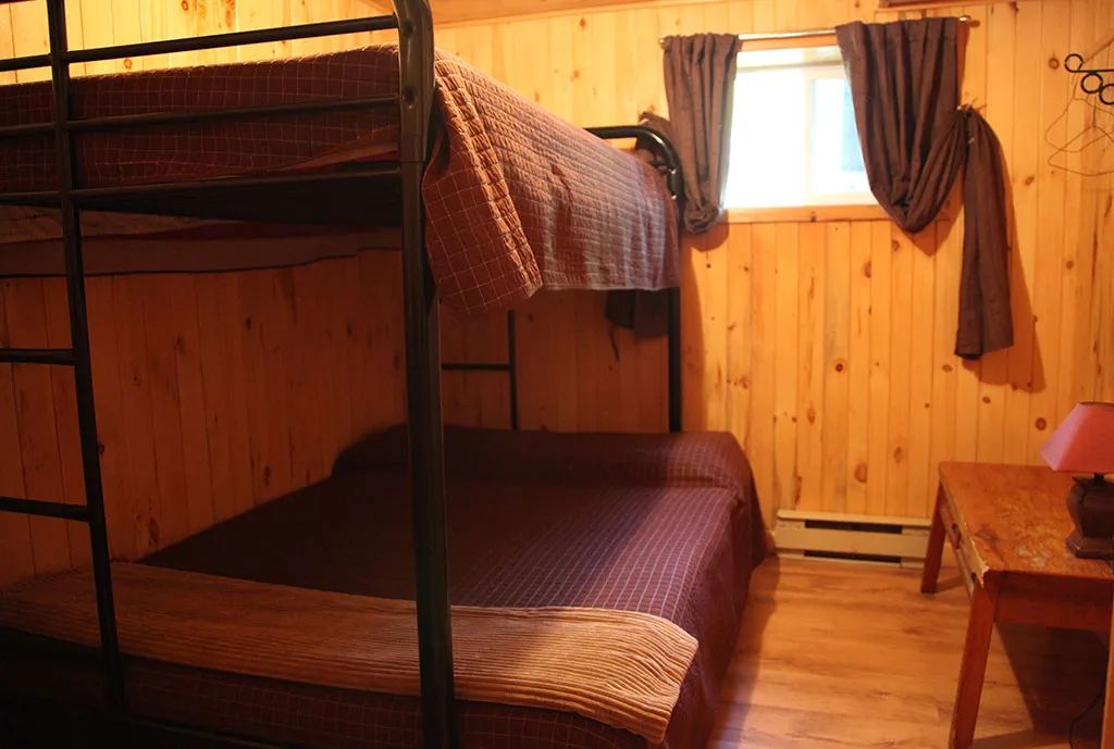 This cottage bedroom is equipped with a metal bunk bed.